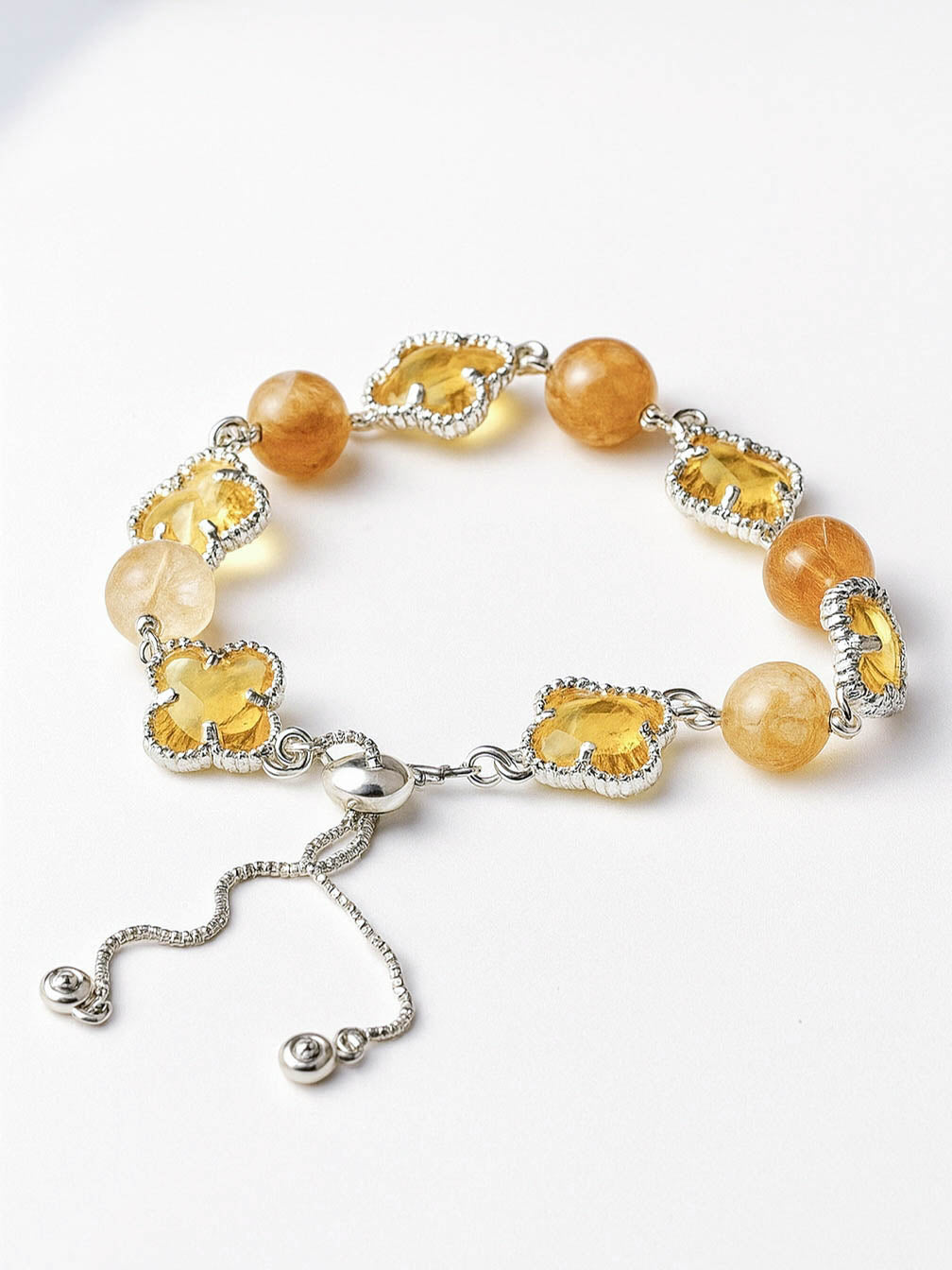 Bracelet with yellow beads and silver clasp on a white background