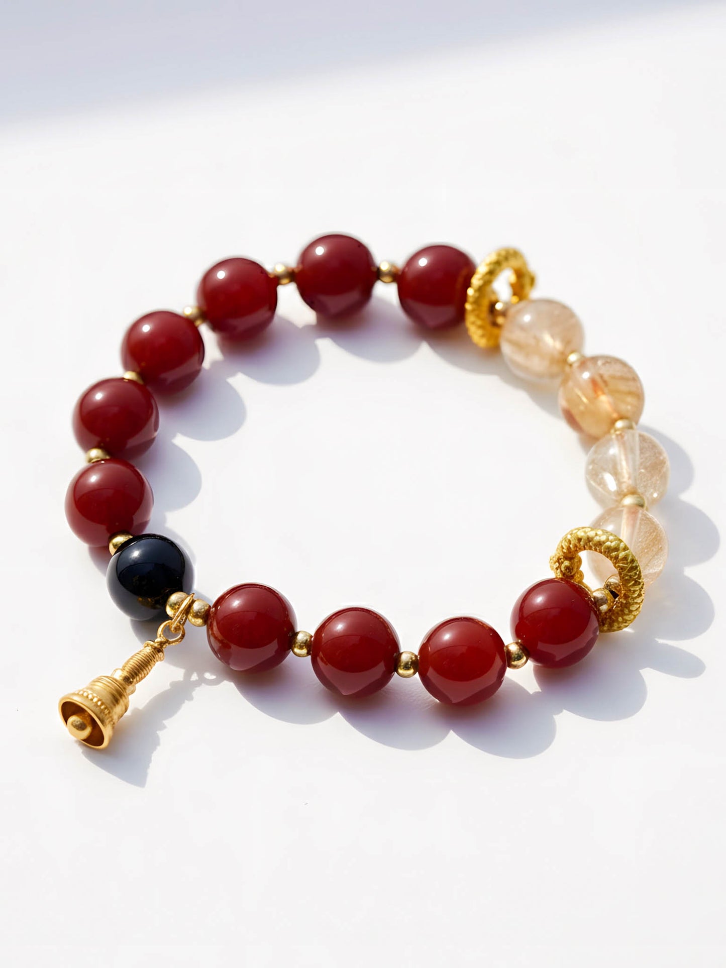 Bracelet with red, black, and gold beads on a white background