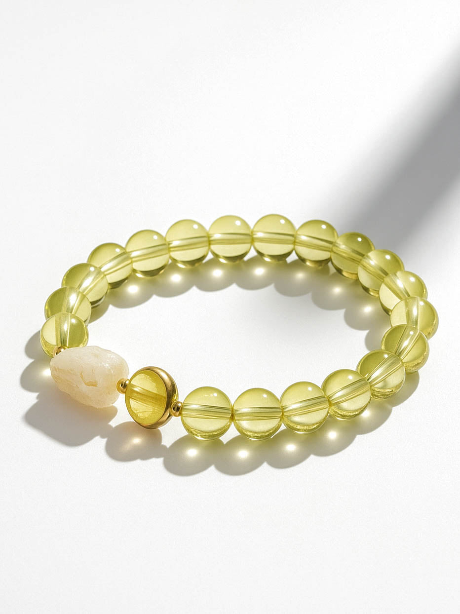 Yellow beaded bracelet with a white bone-like bead on a white background
