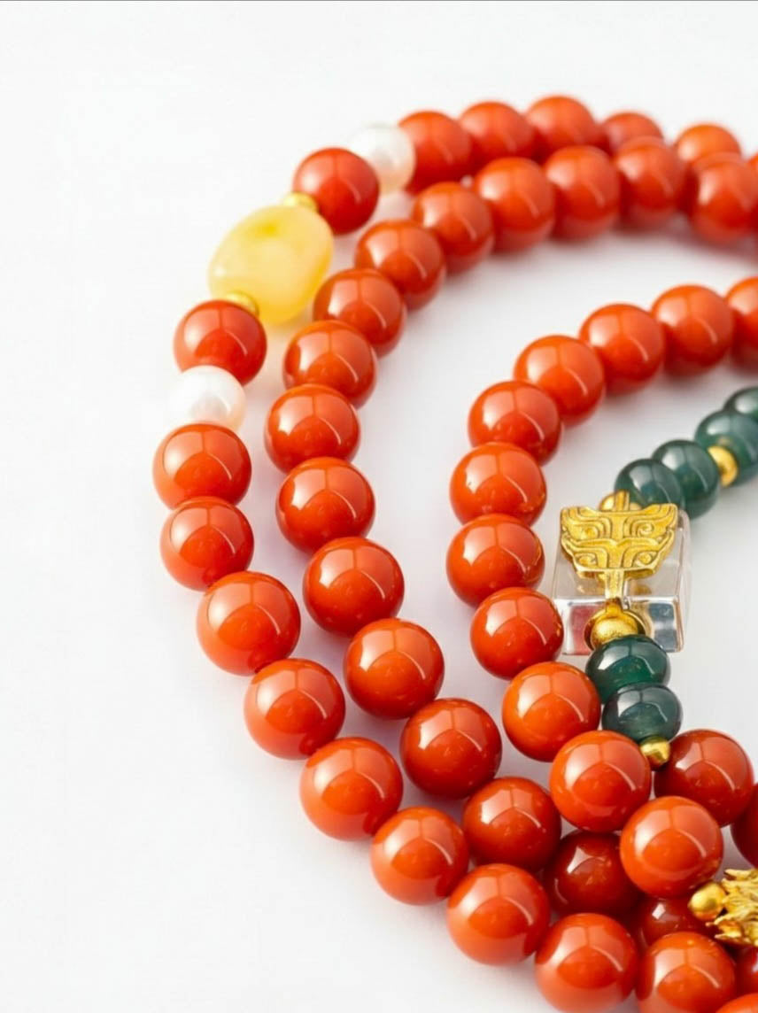 Close-up of a red beaded bracelet with a yellow and green accent bead on a white background