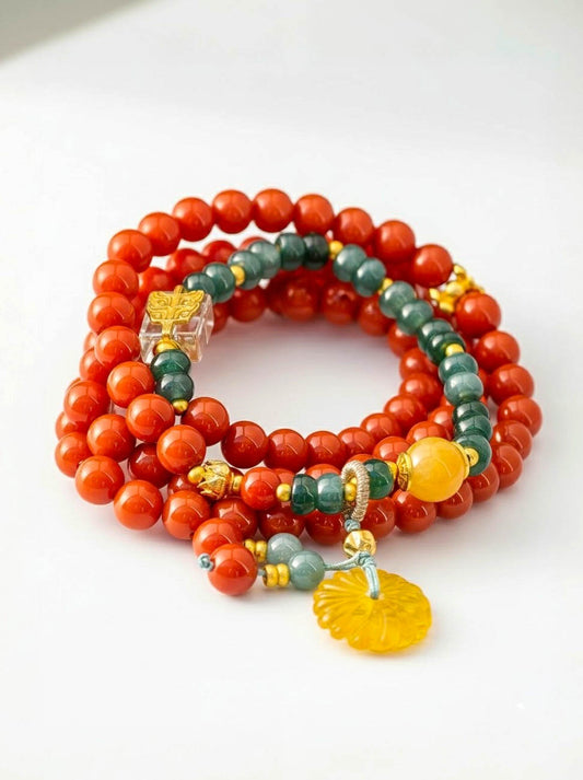 Stack of red and green beaded bracelets with decorative elements on a white background