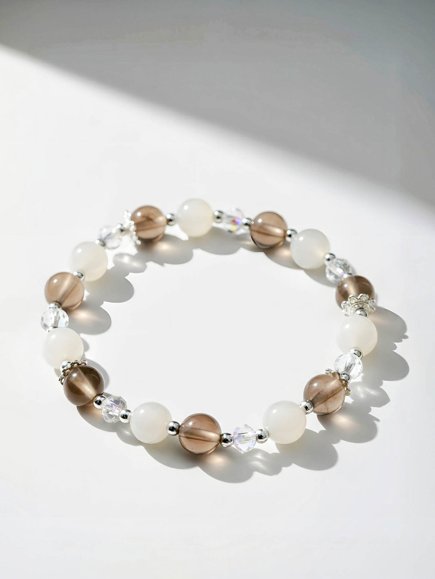 Beaded bracelet with brown, white, and clear beads on a light background