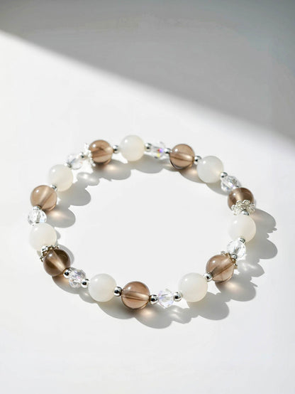 Beaded bracelet with brown, white, and clear beads on a light background