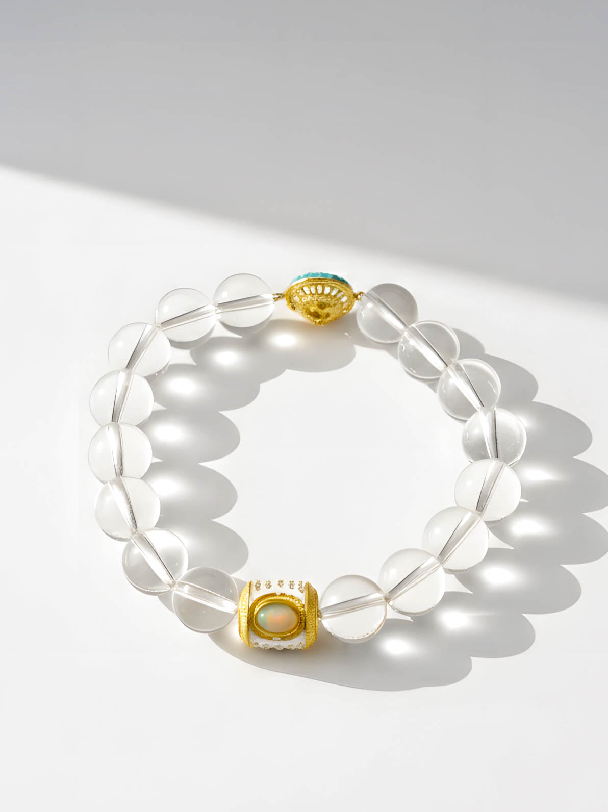 Clear beaded bracelet with gold accents on a white background