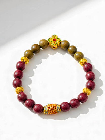 Bracelet with maroon and brown beads and gold accents on a white background