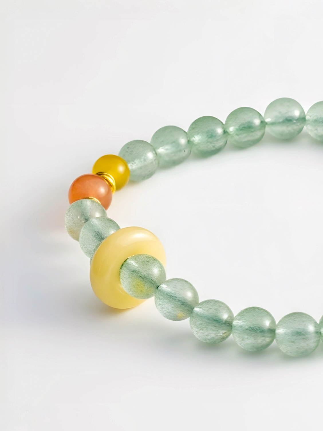Necklace with green beads and colorful accents on a white background