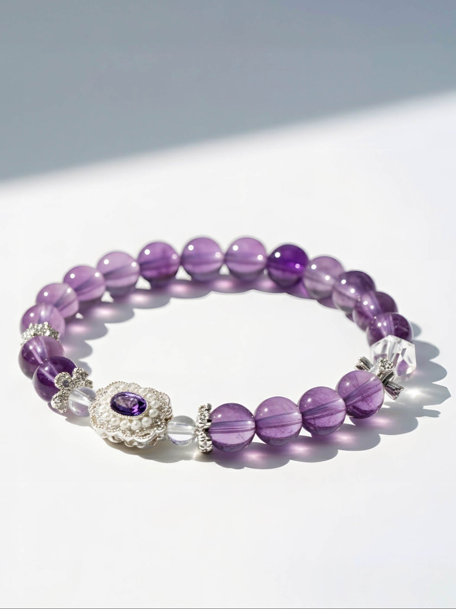 Purple beaded bracelet with a silver clasp on a white background