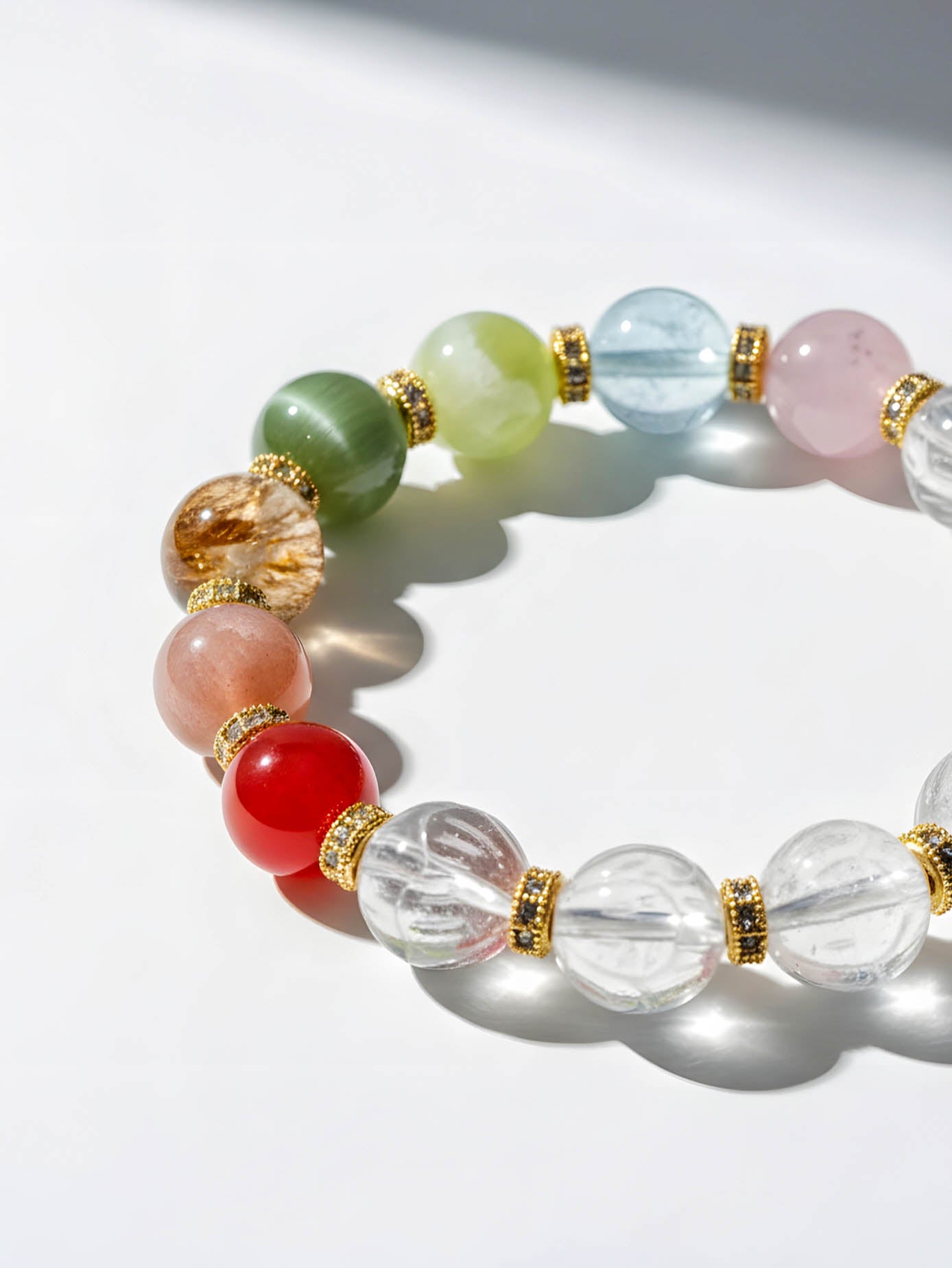 Multicolored beaded bracelet with gold accents on a white background