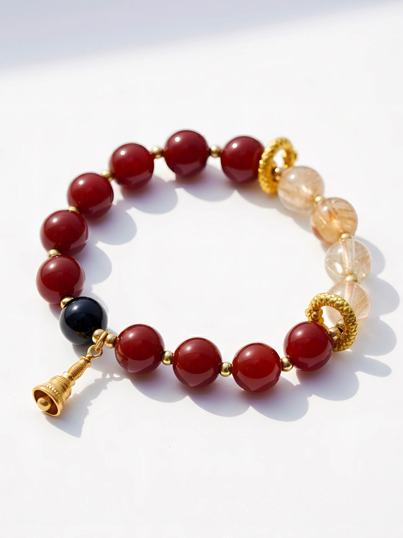Bracelet with red, black, and gold beads on a white background