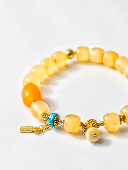 Multicolored beaded bracelet with gold accents on a white background