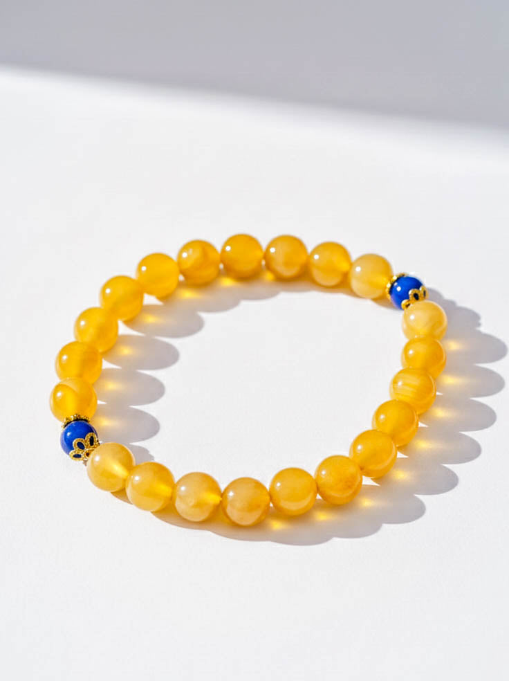 Yellow beaded bracelet with blue accents on a white background