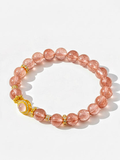 Pink beaded bracelet with gold accents on a white background