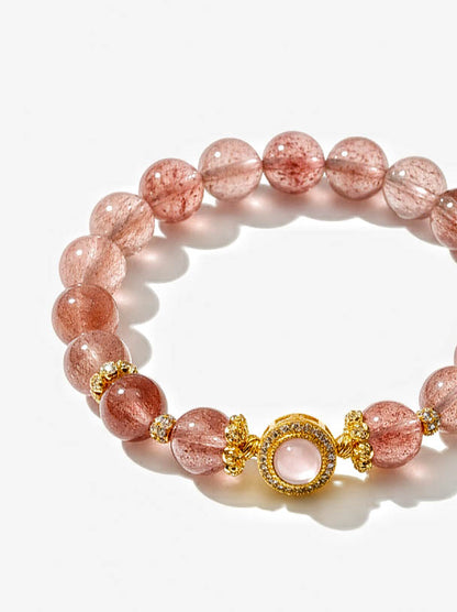 Pink beaded bracelet with gold accents on a white background