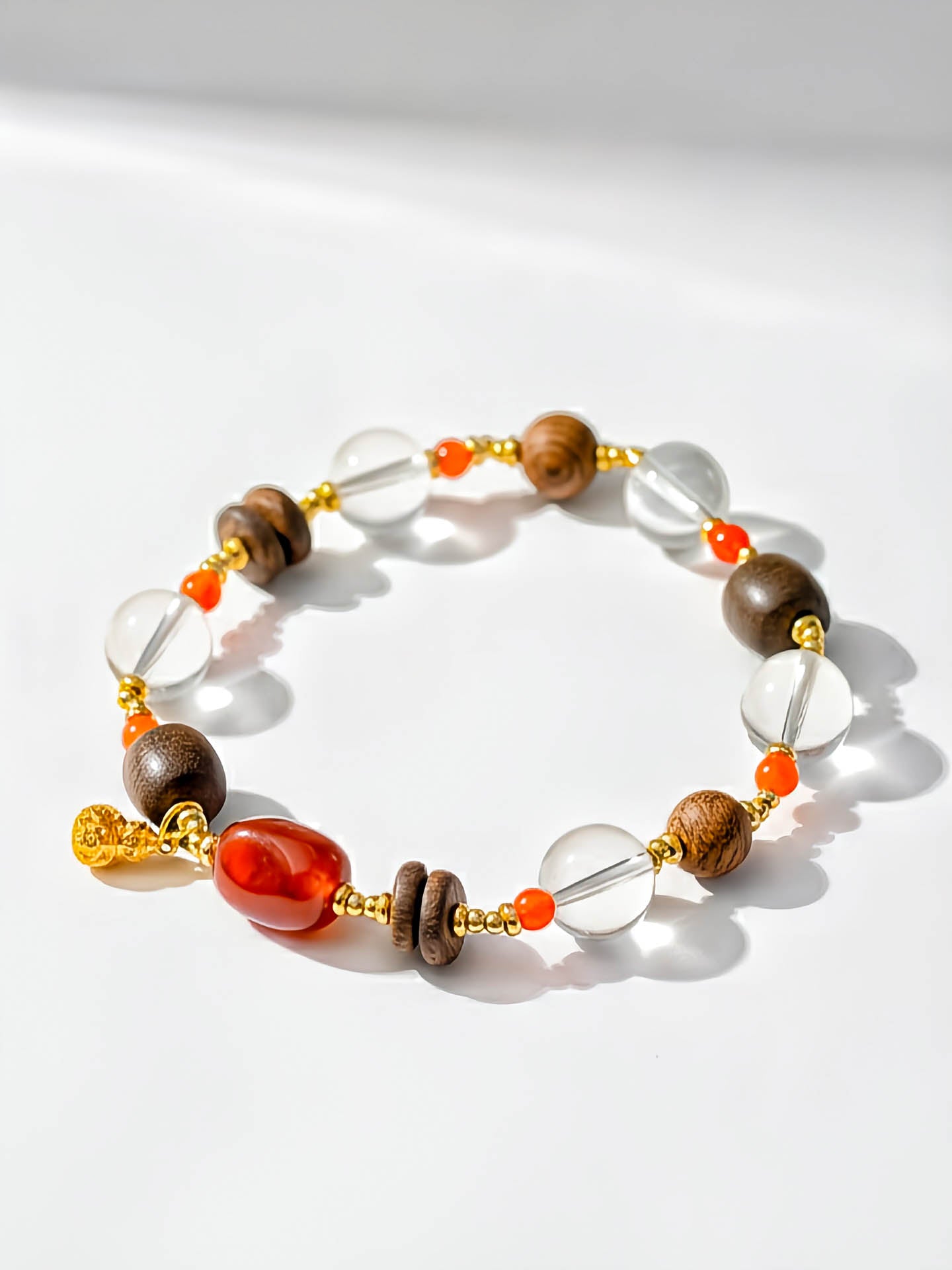 Beaded bracelet with brown, orange, and clear beads on a white background