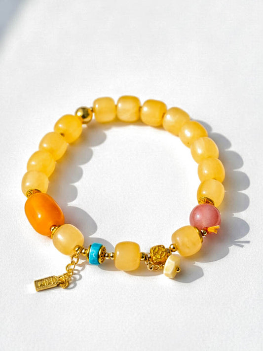 Multicolored beaded bracelet with gold accents on a white background