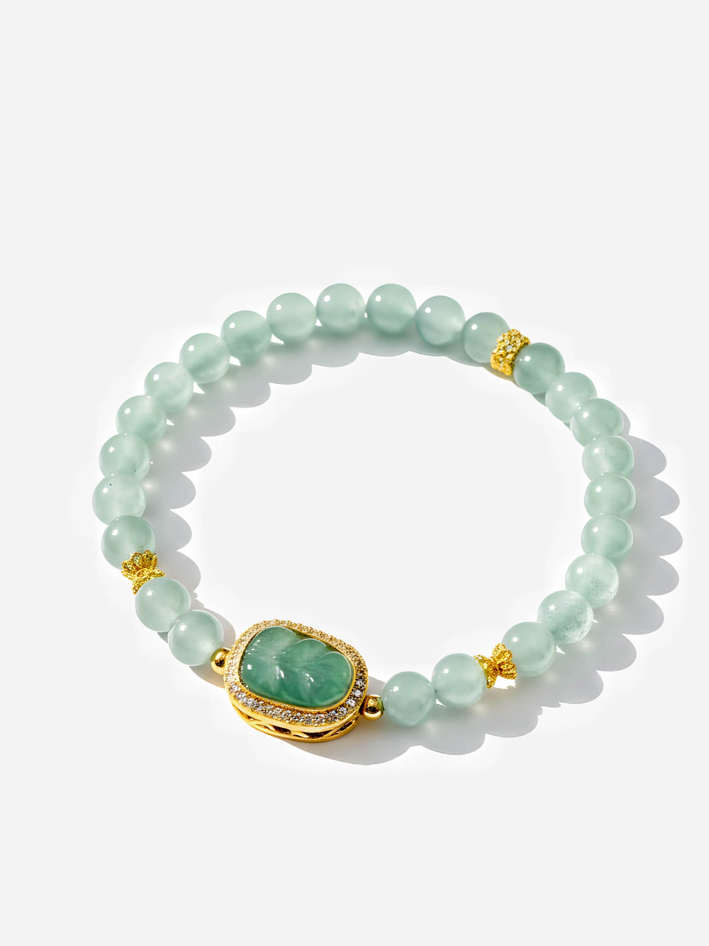 Green beaded bracelet with a gold clasp on a white background