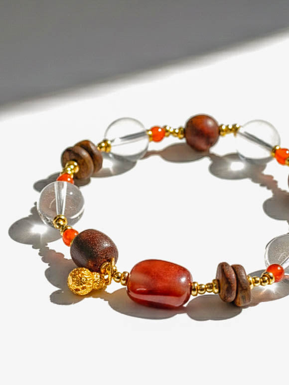 Beaded bracelet with brown, red, and clear beads on a white background