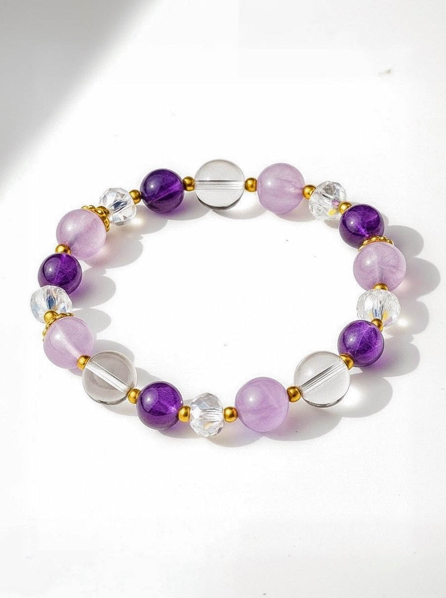 Beaded bracelet with purple, clear, and gold accents on a white background
