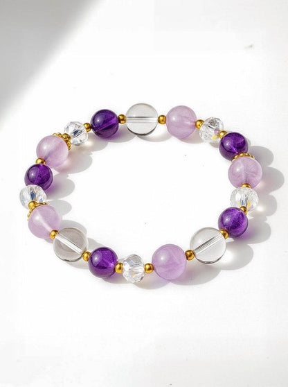 Beaded bracelet with purple, clear, and gold accents on a white background