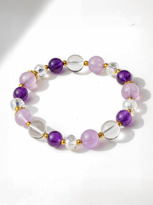 Beaded bracelet with purple, clear, and gold accents on a white background