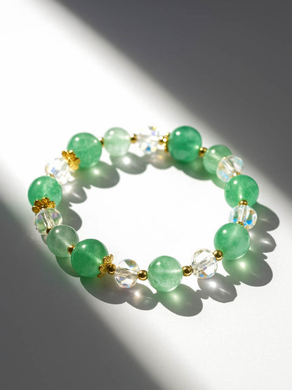 Green beaded bracelet with gold accents on a light background