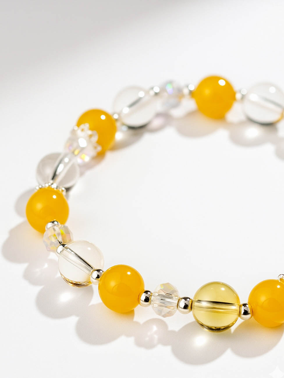 Bracelet with yellow and clear beads on a white background