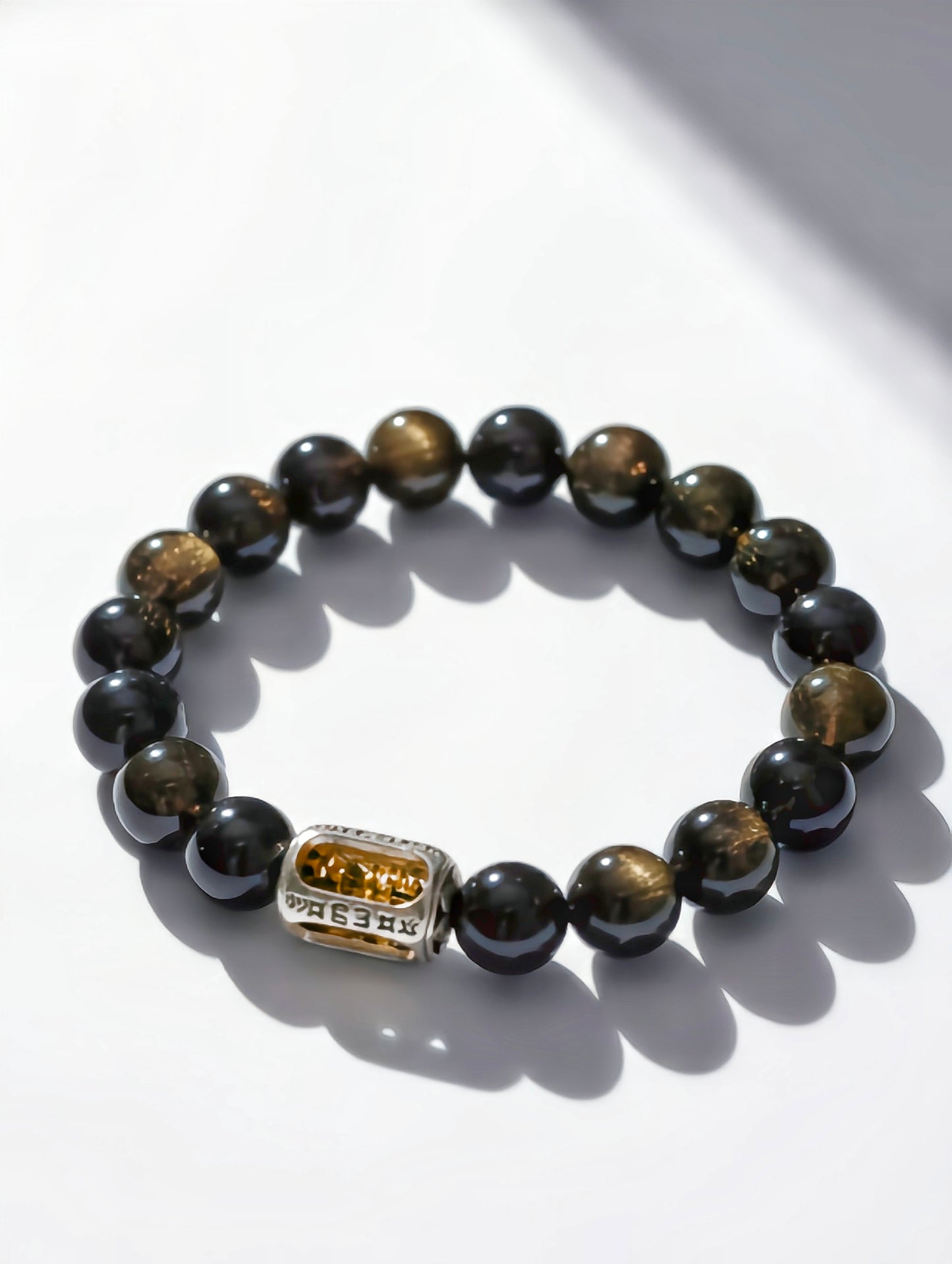 Black beaded bracelet with a gold clasp on a white background