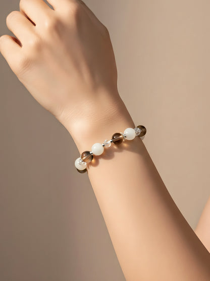 Bracelet with multicolored beads on a wrist against a neutral background