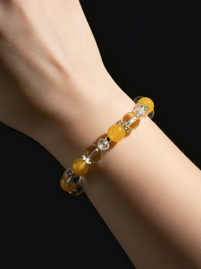 Yellow beaded bracelet on a wrist against a black background