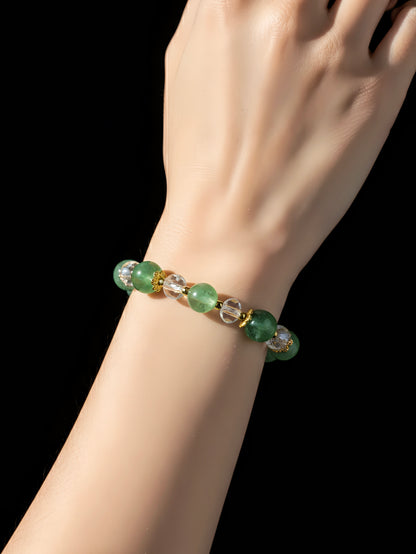 Green beaded bracelet on a wrist against a black background