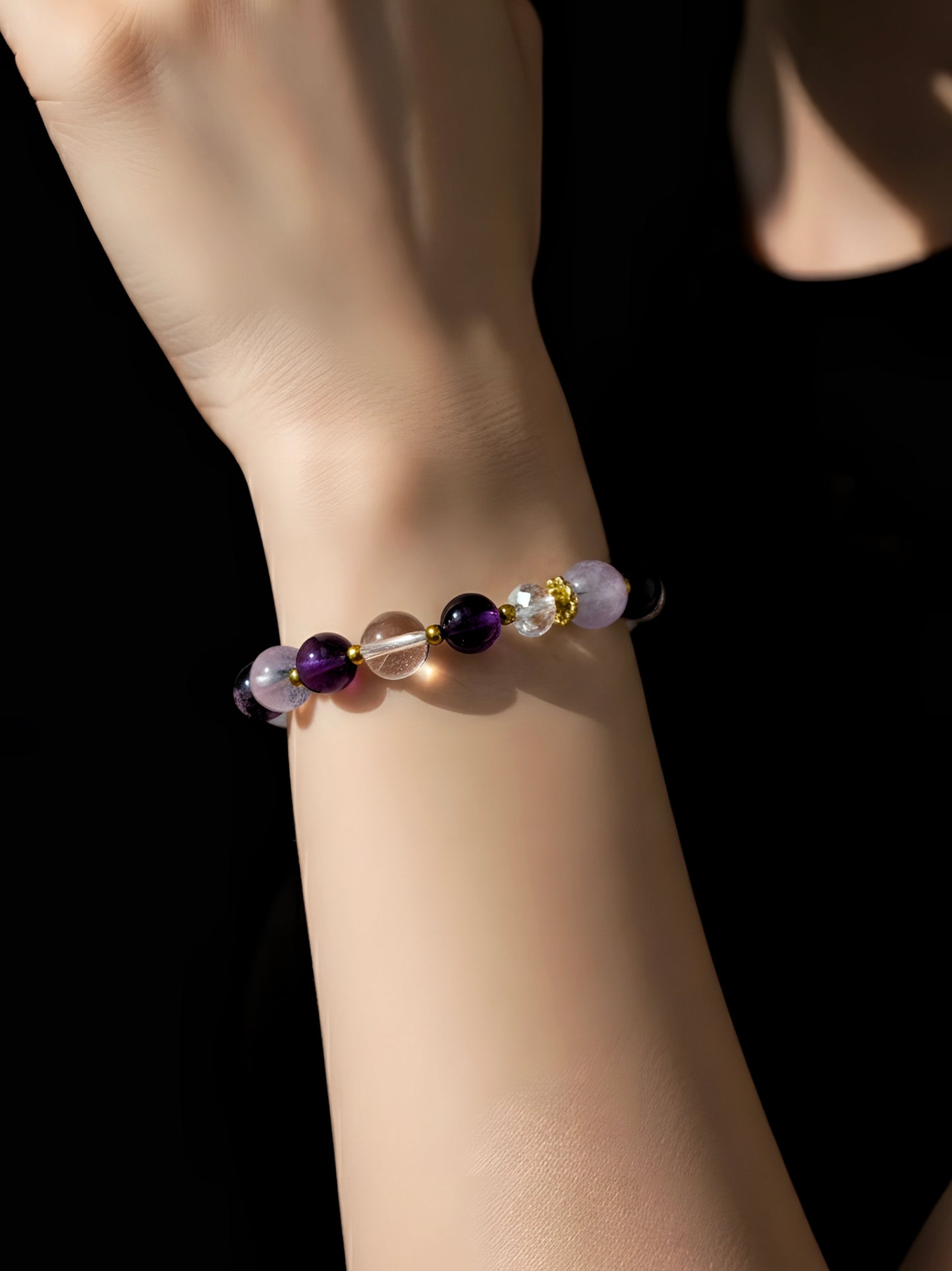Bracelet with colored beads on a wrist against a black background