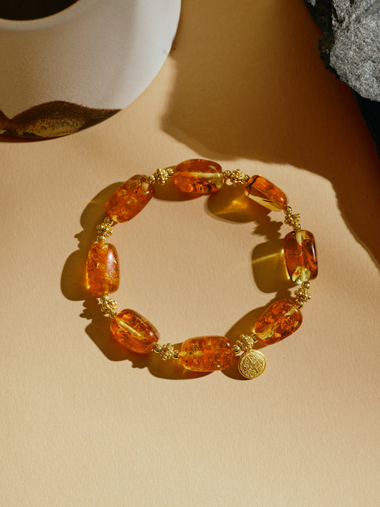 Bracelet with amber-colored beads on a beige surface